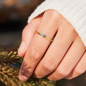 Elegant s925 silver gold ring featuring a heart-shaped blue gemstone on a pine branch