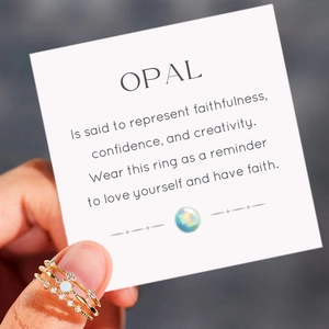 Three-piece gold plated ring set with opal and cubic zirconia shown on hand with card