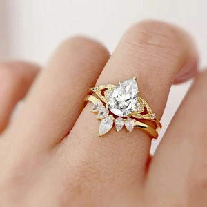 Pear-shaped zircon flower ring set in yellow gold finish with braided band details