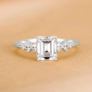 S925 sterling silver emerald cut zircon ring with side stones on silk background