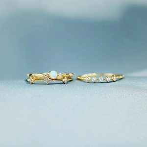 Detailed shot of s925 silver opal flower ring set with accent diamonds on blue silk