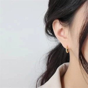 Minimalist gold S925 sterling silver twist rope hoop earrings on a female model
