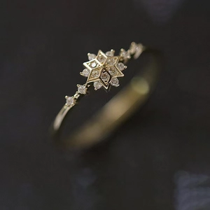 Macro shot of gold snowflake ring featuring a central stone and fine zircon accents