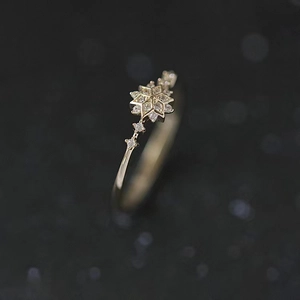 Macro shot of s925 silver snowflake ring in light gold finish with sparkling zircons