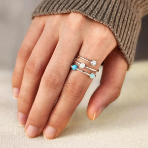 Detail of s925 silver multi-layer ring with opal beads on female hand