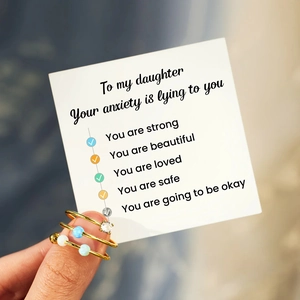 Three-piece gold stacking ring set with white and blue opal stones and card for daughter