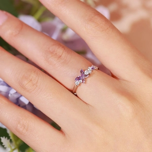Bague élégante en argent 925 avec cristaux papillon violets portée sur un doigt de femme