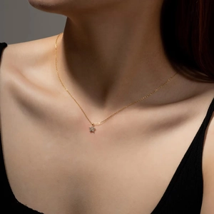 Gold s925 silver necklace with sparkling pavé zircon star pendant worn on collarbone