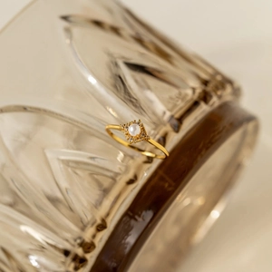 Dettaglio di un anello vintage dorato con perla centrale e pavé di zirconi cubici