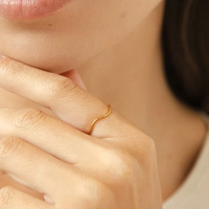 Minimalist S925 sterling silver wavy ring in gold finish worn on a finger