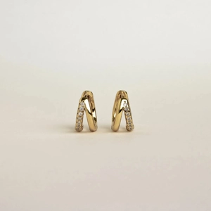 Detail view of double-layer golden V-shaped hoop earrings with sparkling zircon stones
