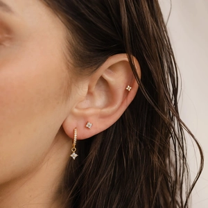 Elegant s925 silver gold clover stud earrings and floral huggie hoops worn on ear
