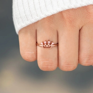 Rose gold S925 sterling silver crown ring with pink zircons on a female finger