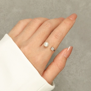Close-up of S925 sterling silver adjustable ring with white pearl and square zircon on hand