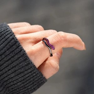 Bague serpent noire moderne sertie de zircons violets portée par un mannequin en plein air