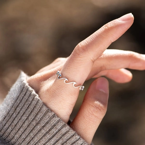 Minimalist S925 sterling silver wave ring with sleek rippled design on a woman finger