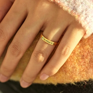 Gros plan d'une bague dorée en argent S925 avec gravure émaillée 'It is what it is'