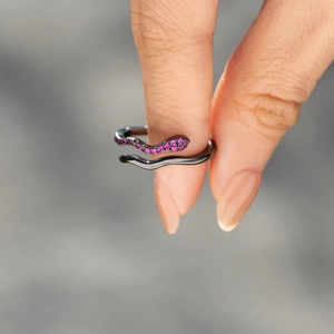 Gros plan d'une bague serpent en argent S925 noir avec zircons violets à la main
