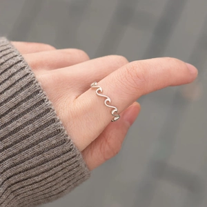 Close-up of s925 silver wave ring on finger with elegant undulating texture design