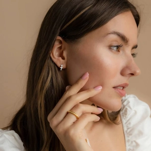 Élégantes boucles d'oreilles en argent S925 et bague torsadée dorée sur le mannequin