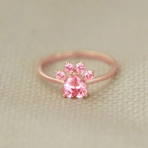 Macro shot of rose gold cat paw ring with heart-shaped pink stone and small side gems