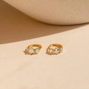 Détail de boucles d'oreilles en argent doré avec zircons cubiques et coupe princesse