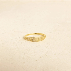 Elegant gold S925 silver ring with three rows of paved zircon stones on stone background