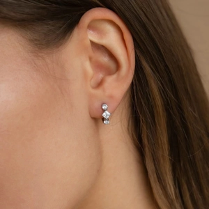 Détail de boucles d'oreilles en argent 925 avec trois zircons verticaux portées