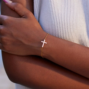 Bracelet élégant en argent s925 doré avec pendentif croix porté sur le poignet