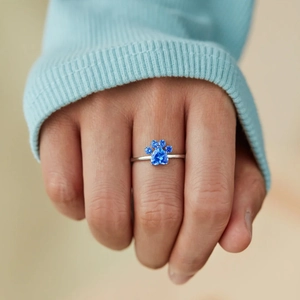 S925 sterling silver puppy paw ring with blue heart gemstone on a model hand