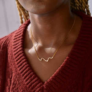 Elegant gold S925 sterling silver wavy necklace with zircons worn on a model