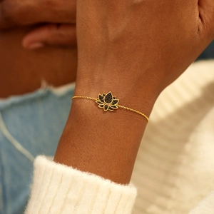 Gros plan du bracelet lotus en argent S925 avec pierres noires sur le poignet d'une femme