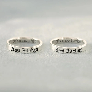Macro shot of S925 sterling silver rings with Take No Shit and Give No Fucks engravings