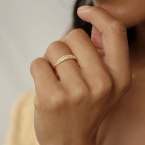 Close-up of elegant gold ring with triple-row pavé cubic zirconia on model's hand