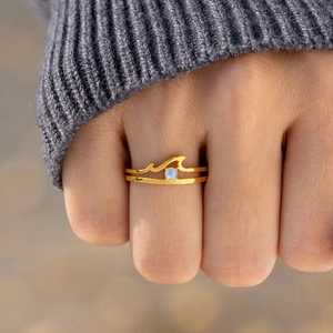 Golden double layer wave ring with opal stone shown on a model's finger