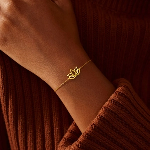 Gros plan détaillé d'un bracelet lotus doré orné de pierres brillantes sur un poignet