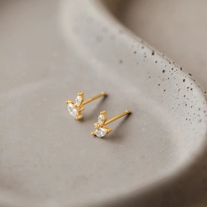 Detailed view of leaf-shaped gold stud earrings with marquise-cut cubic zirconia stones