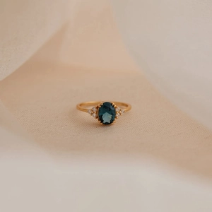 Elegant gold S925 silver ring with oval blue sapphire and side accent diamonds