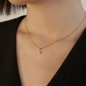 Close-up of a gold s925 sterling silver heart lock pendant necklace on female model