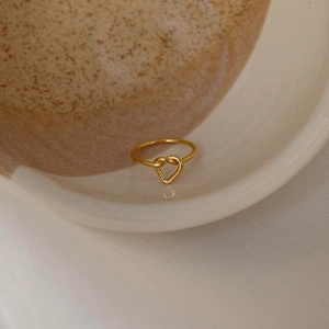 Bague cœur élégante en argent s925 doré disposée sur un plateau en céramique