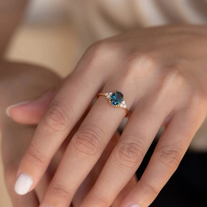 Elegant S925 silver gold-plated ring with oval deep blue gemstone and side diamonds