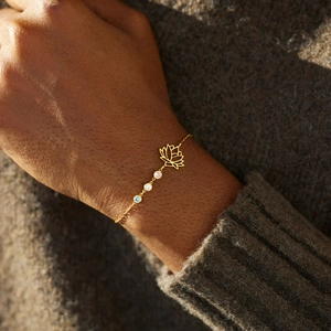 Gold s925 silver lotus bracelet with three colorful gemstones worn on woman's wrist