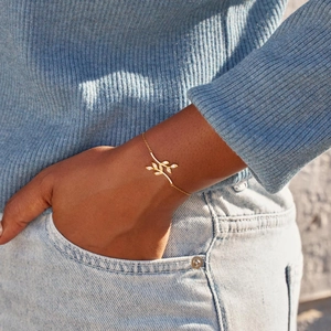 Elegant gold olive leaf bracelet with sparkling zircon stones on a model's wrist