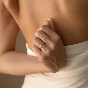 Bague cœur noué minimaliste en argent S925 doré portée sur la main d'une femme