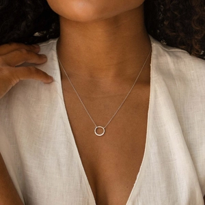 Close-up of S925 sterling silver circle necklace with zircon pavé on a model