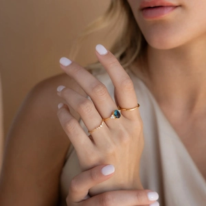 Elegant gold stacked ring set with oval blue gemstone and shimmering side diamonds