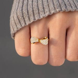 Elegant gold S925 sterling silver bow ring with sparkling pavé diamonds on finger