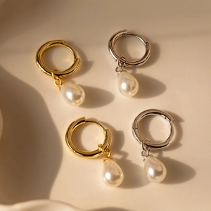 Elegant s925 silver and gold hoop earrings with white freshwater pearl drops on tray