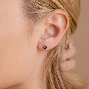 Élégante boucle d'oreille fleur noire en argent S925 portée par un mannequin chic