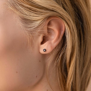 Puce d'oreille fleur noire en argent S925 avec zircon blanc portée sur l'oreille